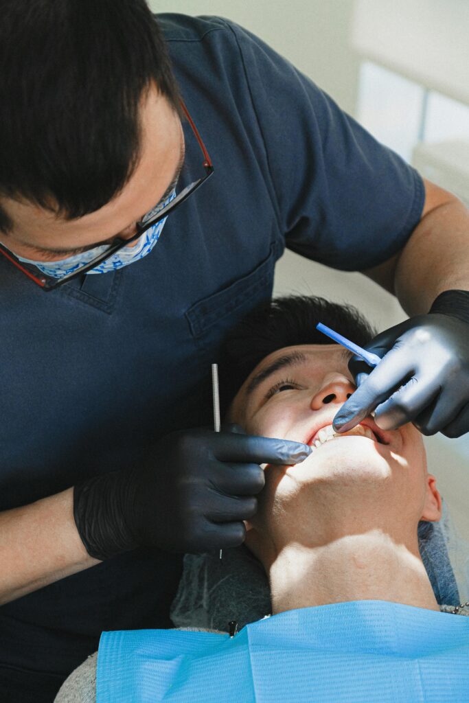 A patient receives dental care from a professional dentist in a clinic setting.